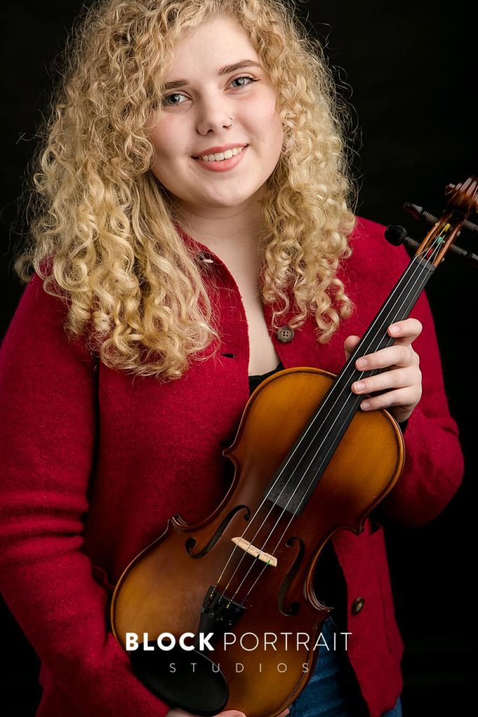 Girl smiling and holding a violin