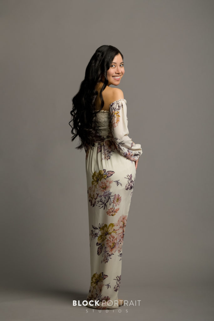 Professional portrait of latina woman standing in floral dress, by Twin Cities family photographer