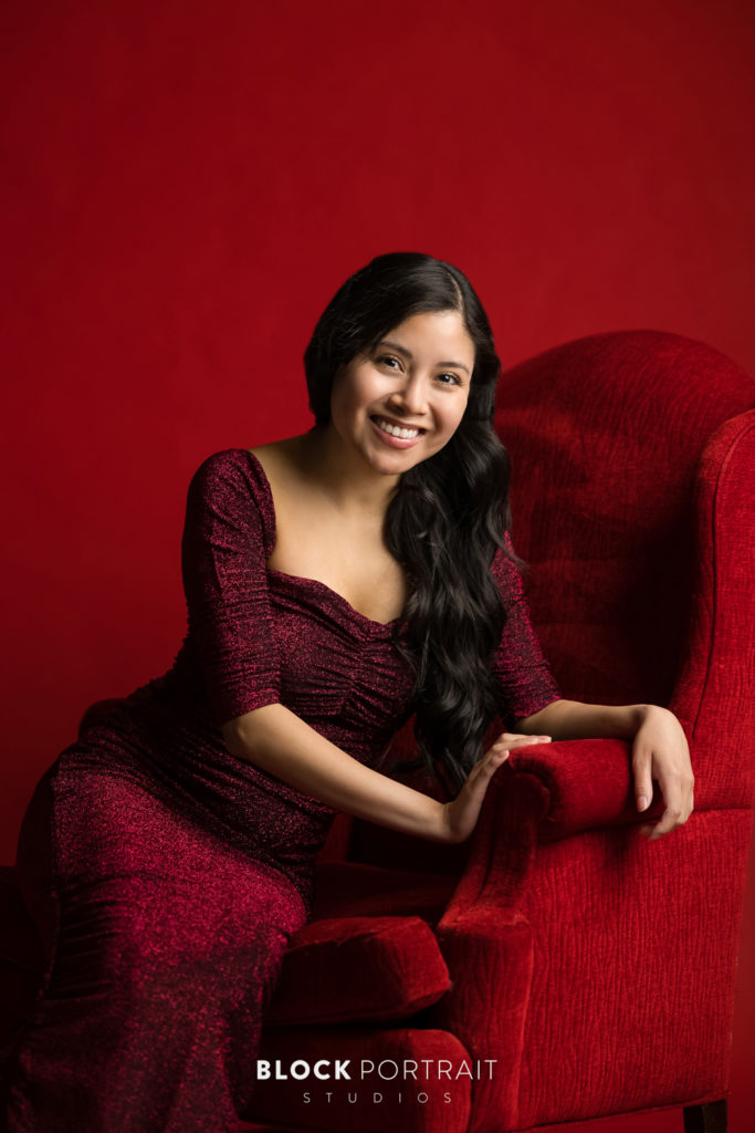 Online dating headshot of latina woman on red chair, by Twin Cities photographer