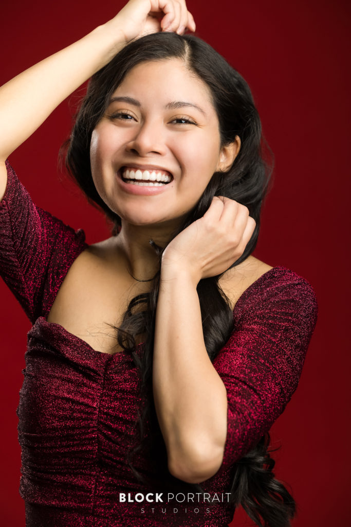Headshot of laughing latina woman in sparkly red dress, by MPLS model photographer
