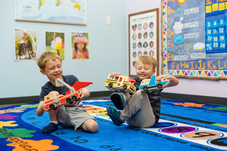 Two boys playing with toys at Twin Cities preschool. Photography by Block Portrait Studios