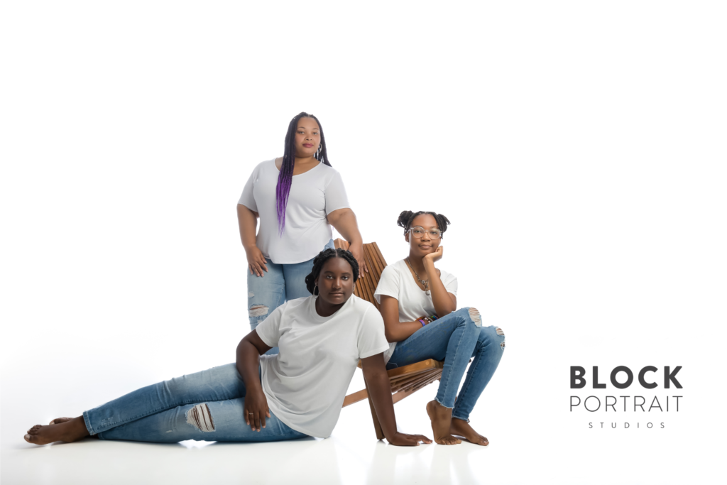 African American mother standing with her two African American teenage daughters, in a white room, all wearing white t-shirts, and denim jeans helping her children after divorce.