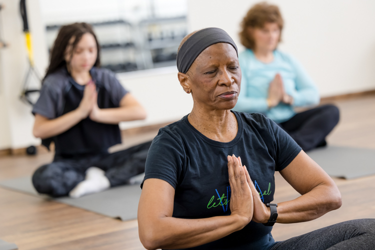 Black woman in yoga pose practicing at St. Paul fitness studio photographed by Block Portrait Studios